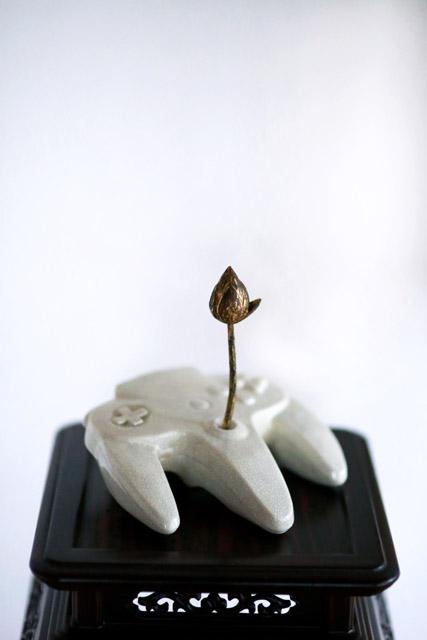 現代的なモチーフを陶器で制作して花器に見立て、伝統的な仏具「常花」(じょうか)を生ける〈ALLDAY TODAY〉シリーズより 《-controller-》2018年、陶器、木、金箔